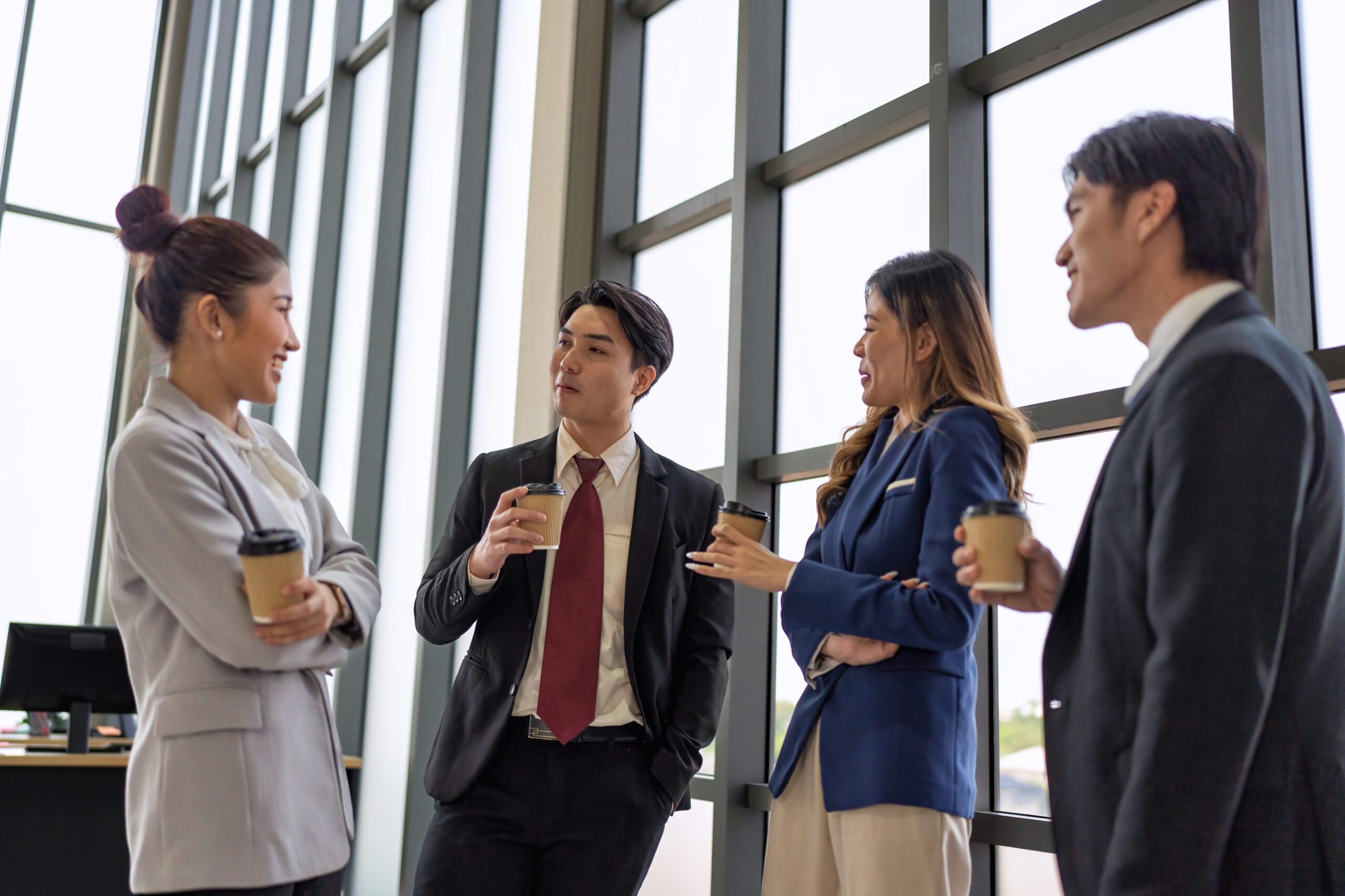 Business meeting of business people in office formal wear stand hold glass of coffee on break time