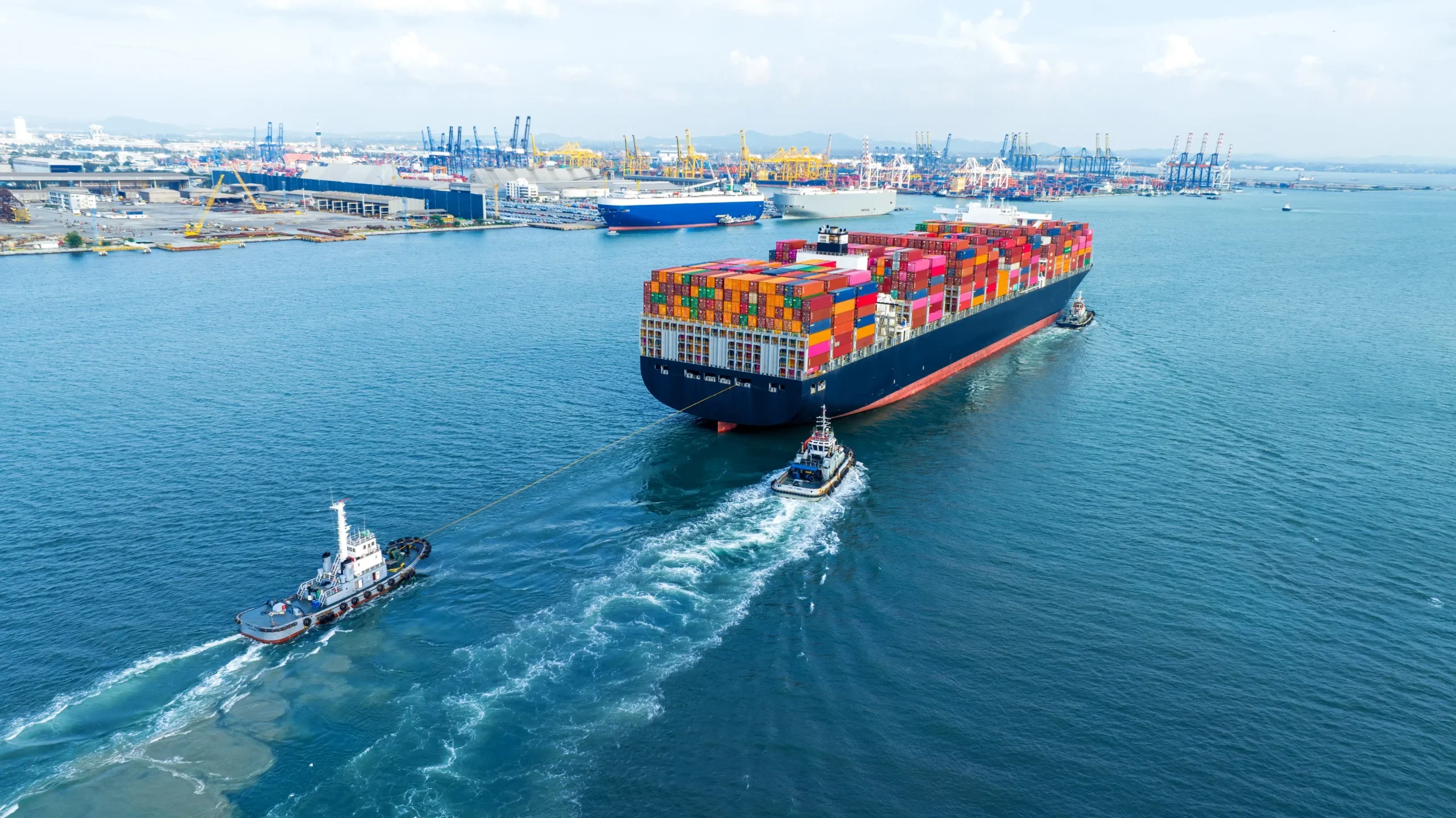 tub-boat-with-stern-of-cargo-ship-carrying-contain-2024-12-08-00-46-58-utc